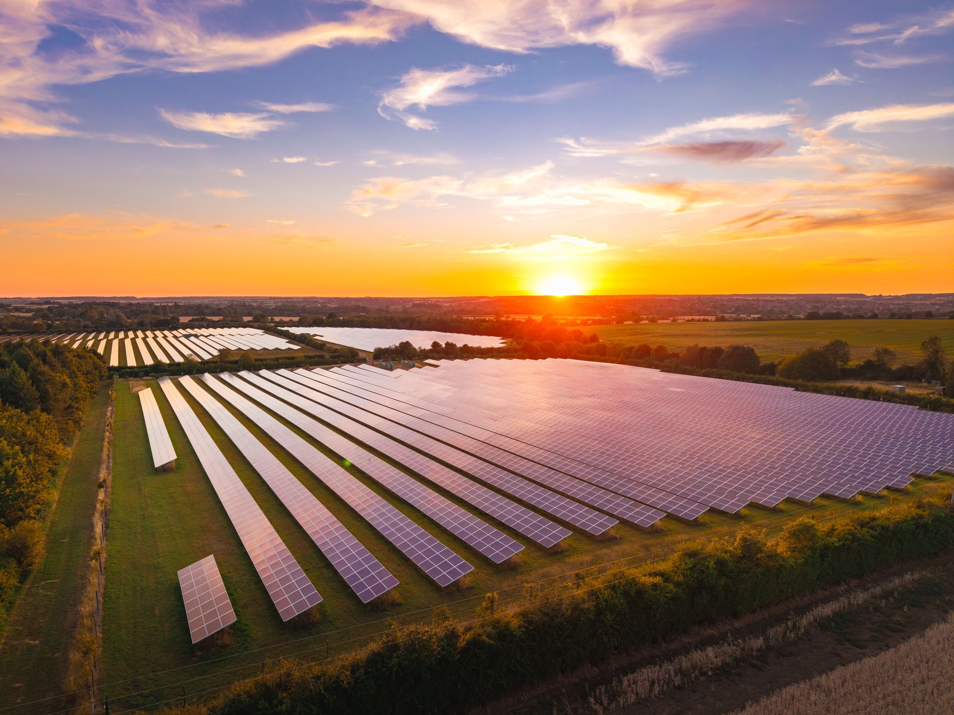 Aerial view of a solar farm at sunset, providing sustainable energy